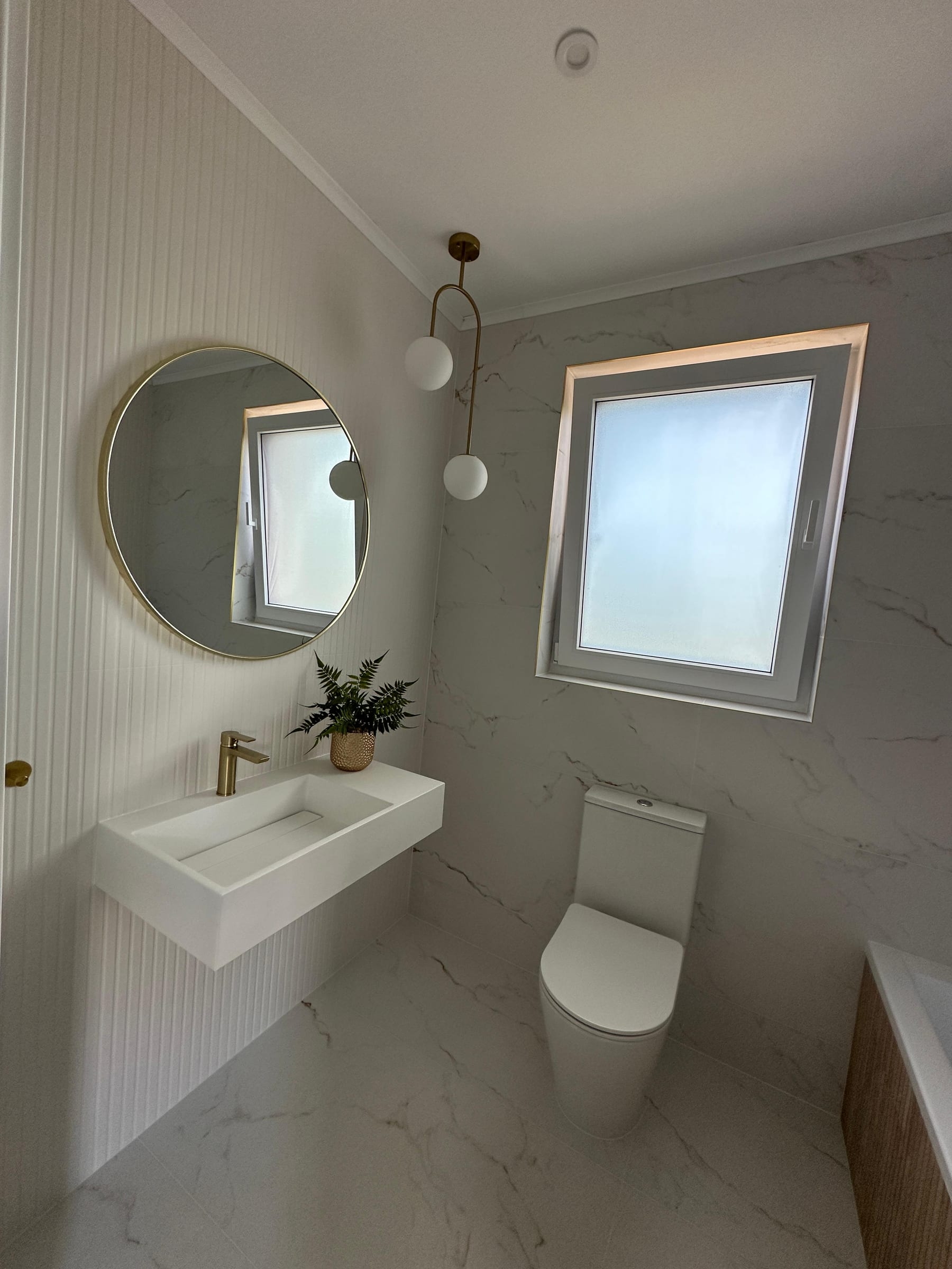 Fluted oak and marble-effect bathroom by Mark & Patryk Property Maintenance