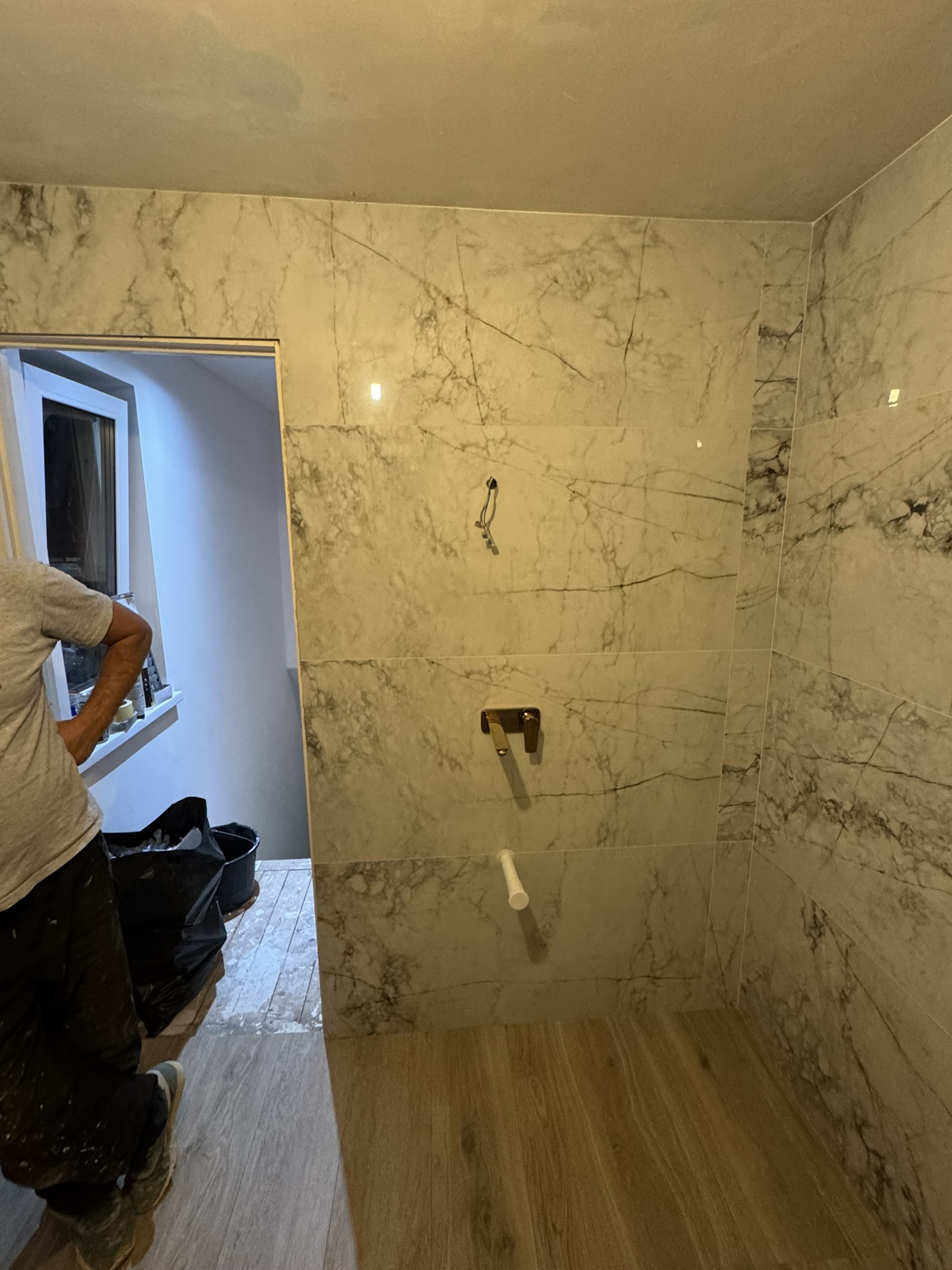 Marble-tiled shower wall fitted by Mark & Patryk